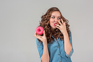 Image showing The smiling girl on gray studio background with round cake