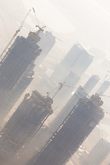 Image showing Skyscrappers construction site with cranes on top of buildings.