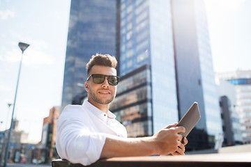 Image showing man with tablet pc sitting on city street bench