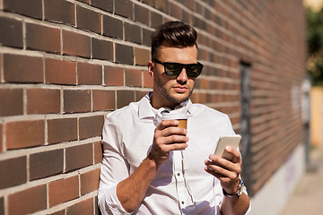 Image showing man with smartphone and coffee cup on city street