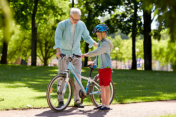 Image showing grandfather and boy with bicycle at summer park