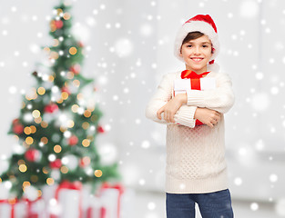 Image showing smiling happy boy in santa hat with gift box