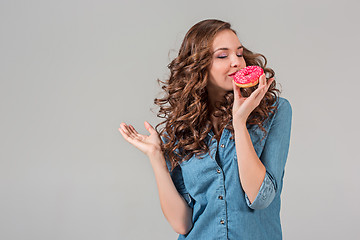 Image showing The smiling girl on gray studio background with round cake