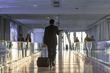 Image showing Businessman at airport corridor walking to departure gates.