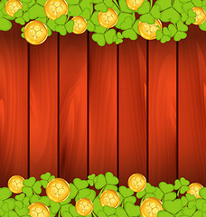 Image showing Clovers and golden coins on brown wooden background for St. Patr