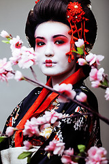 Image showing young pretty geisha in kimono on white background