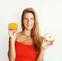Image showing young blonde woman choosing between donut and orange fruit isola