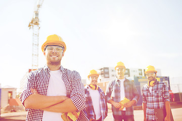 Image showing group of smiling builders in hardhats outdoors