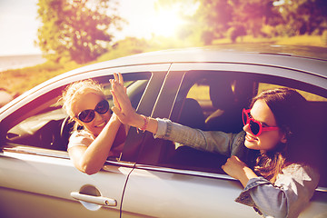 Image showing happy teenage girls or women in car at seaside