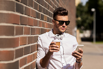 Image showing man with smartphone and coffee cup on city street