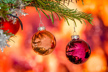 Image showing Shiny Christmas baubles hanging on a branch