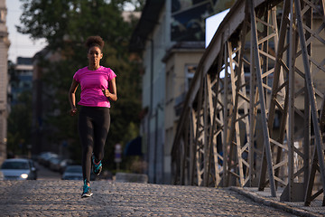 Image showing african american woman running across the bridge