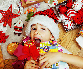 Image showing little cute kid in santas red hat with handmade gifts, toys vint