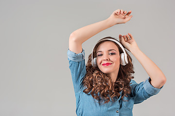 Image showing Happy young woman listening music with headphones.