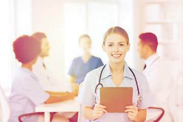 Image showing happy doctor with tablet pc over team at clinic