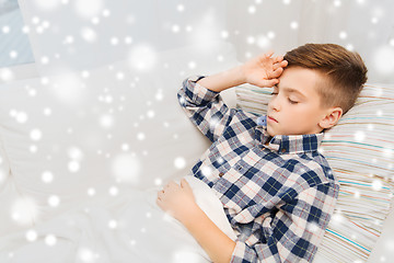 Image showing ill boy lying in bed and suffering from headache