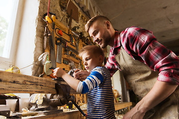 Image showing father and son with plane shaving wood at workshop