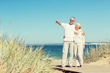 Image showing happy senior couple hugging on summer beach