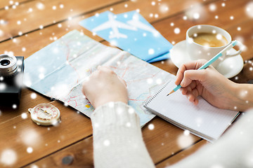 Image showing hands with map and coffee writing to notebook