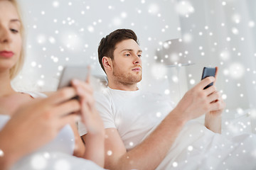 Image showing couple with smartphones in bed