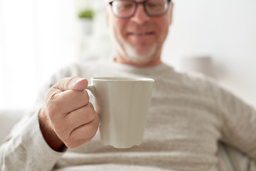 Image showing happy senior man with cup of tea or coffee at home