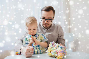 Image showing father and son playing with ball clay at home