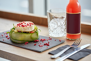 Image showing salad, bottle of drink, glass and cutlery on table