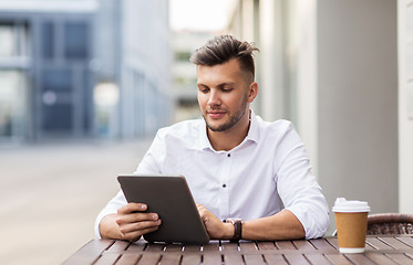 Image showing man with tablet pc and coffee at city cafe