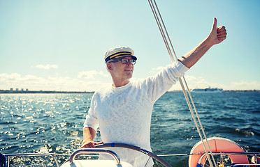 Image showing senior man at helm on boat or yacht sailing in sea