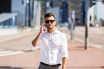 Image showing happy man with smartphone calling on city street