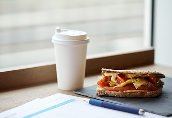 Image showing salmon panini sandwich and cup of drink at cafe