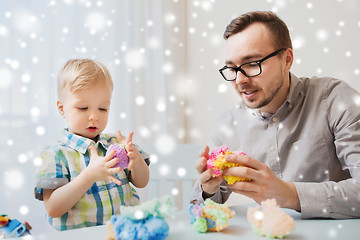 Image showing father and son playing with ball clay at home