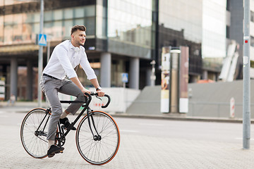 Image showing man with headphones riding bicycle on city street