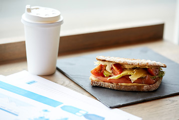 Image showing salmon panini sandwich and cup of drink at cafe