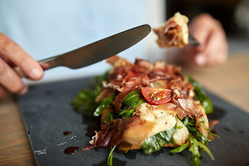 Image showing woman eating prosciutto ham salad at restaurant