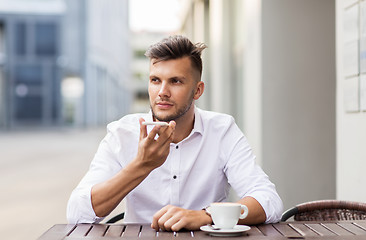 Image showing man with coffee and smartphone at city cafe