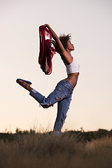 Image showing black girl dances outdoors in a meadow