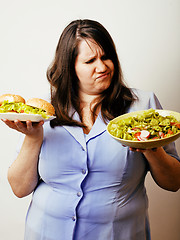 Image showing fat white woman having choice between hamburger and salad close 