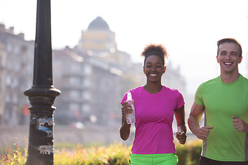 Image showing young multiethnic couple jogging in the city