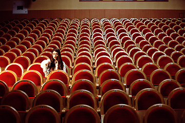 Image showing portrait of a pretty girl hipster in a movie theater wearing hat, dreaming alone, lifestyle people concept