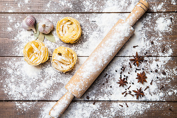 Image showing Wooden rolling pin with flour and pasta