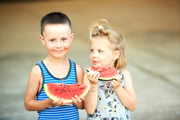 Image showing Young girl and boy eating watermelon