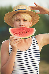 Image showing Beautiful girl in straw hat eating fresh watermelon. Film camera style