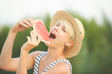 Image showing Beautiful girl in straw hat eating fresh watermelon. Film camera style