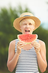 Image showing Beautiful girl in straw hat eating fresh watermelon. Film camera style