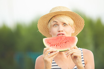 Image showing Beautiful girl in straw hat eating fresh watermelon. Film camera style