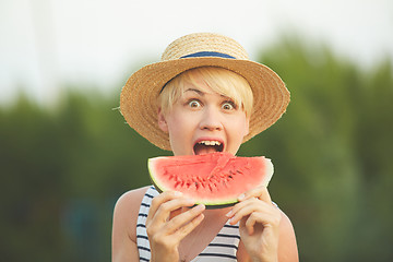 Image showing Beautiful girl in straw hat eating fresh watermelon. Film camera style