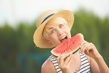 Image showing Beautiful girl in straw hat eating fresh watermelon. Film camera style