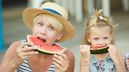 Image showing Mother And Daughter Enjoying Slices Of WaterMelon