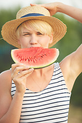 Image showing Beautiful girl in straw hat eating fresh watermelon. Film camera style